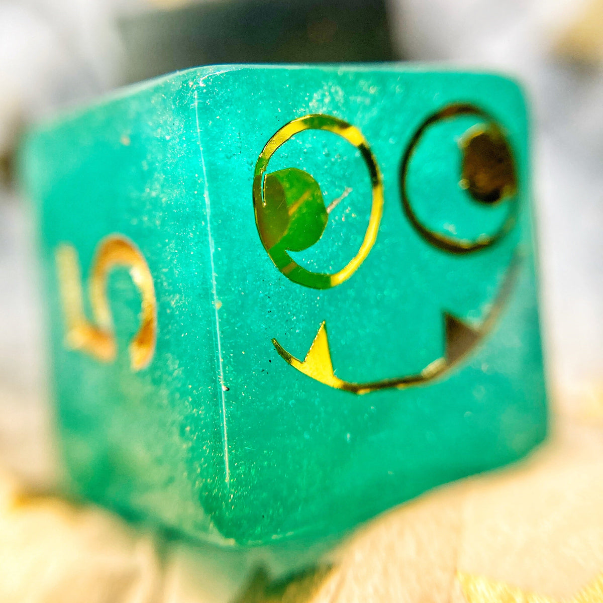 Tusktooth Fjord Inspired D6 – Handmade Glow-in-the-Dark Green & Blue Gaming Die with Gold Grinning Face