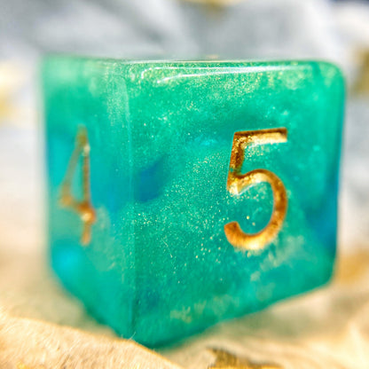 Tusktooth Fjord Inspired D6 – Handmade Glow-in-the-Dark Green & Blue Gaming Die with Gold Grinning Face