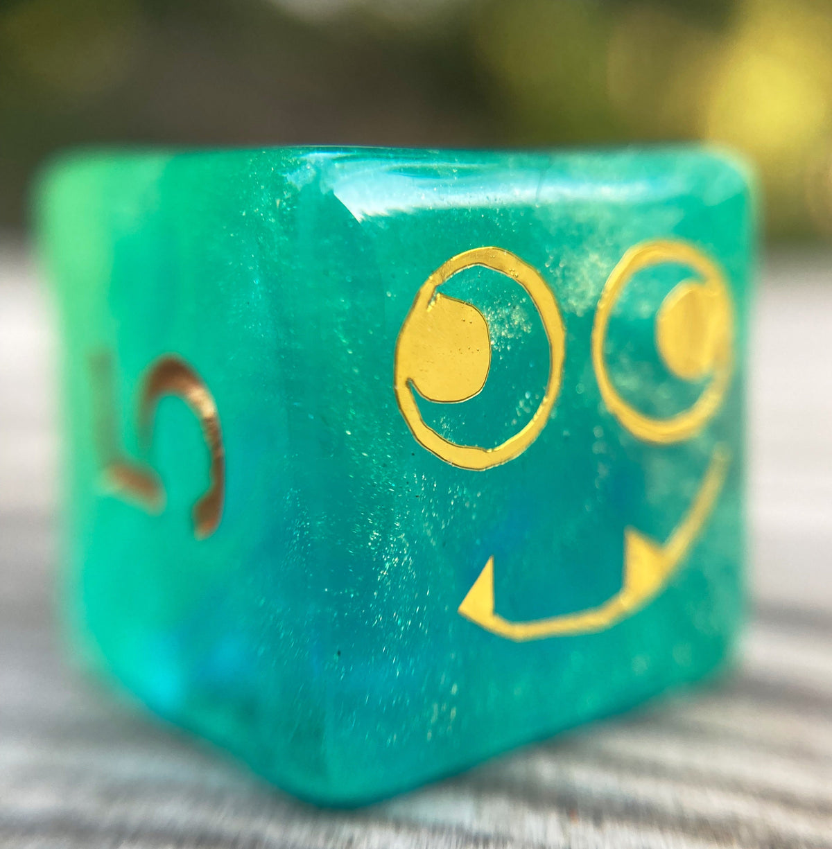 Tusktooth Fjord Inspired D6 – Handmade Glow-in-the-Dark Green & Blue Gaming Die with Gold Grinning Face