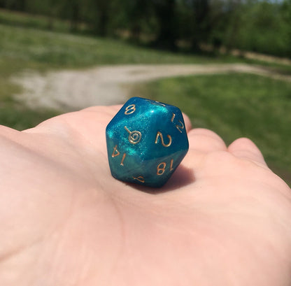 Jester Inspired D20 – Handmade Shimmering Blue Gaming Die with Metallic Gold Numbers & Lollipop Symbol