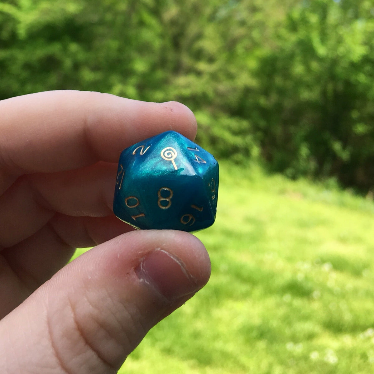 Jester Inspired D20 – Handmade Shimmering Blue Gaming Die with Metallic Gold Numbers & Lollipop Symbol